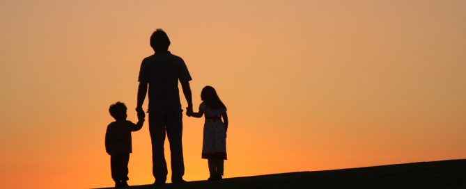 Silhouette of a father and his children