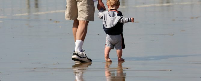 father and son walking on the beach