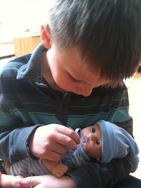 boys playing with baby dolls